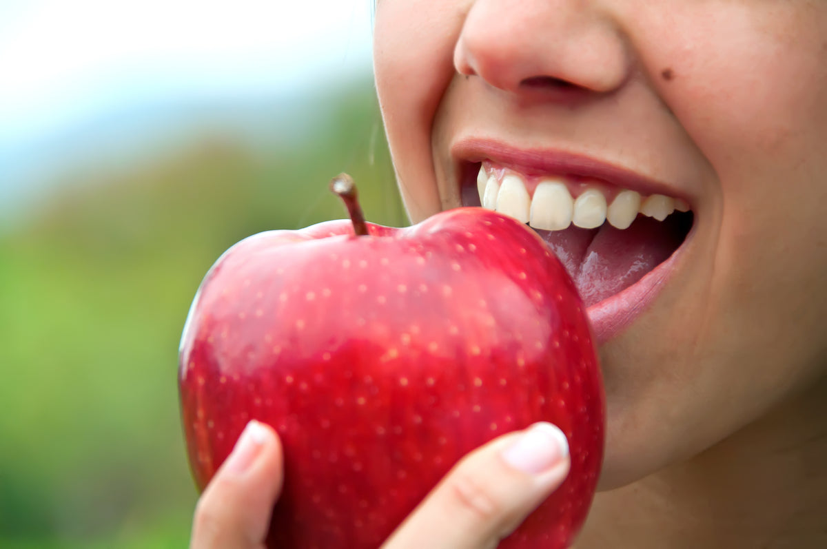 Frau beißt in einen Apfel
