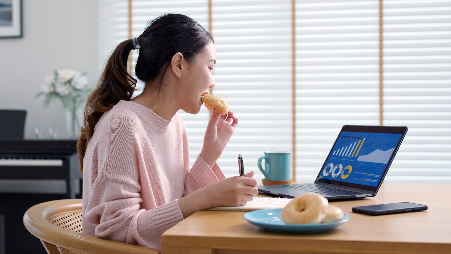 Frau isst Donuts am Arbeitsplatz