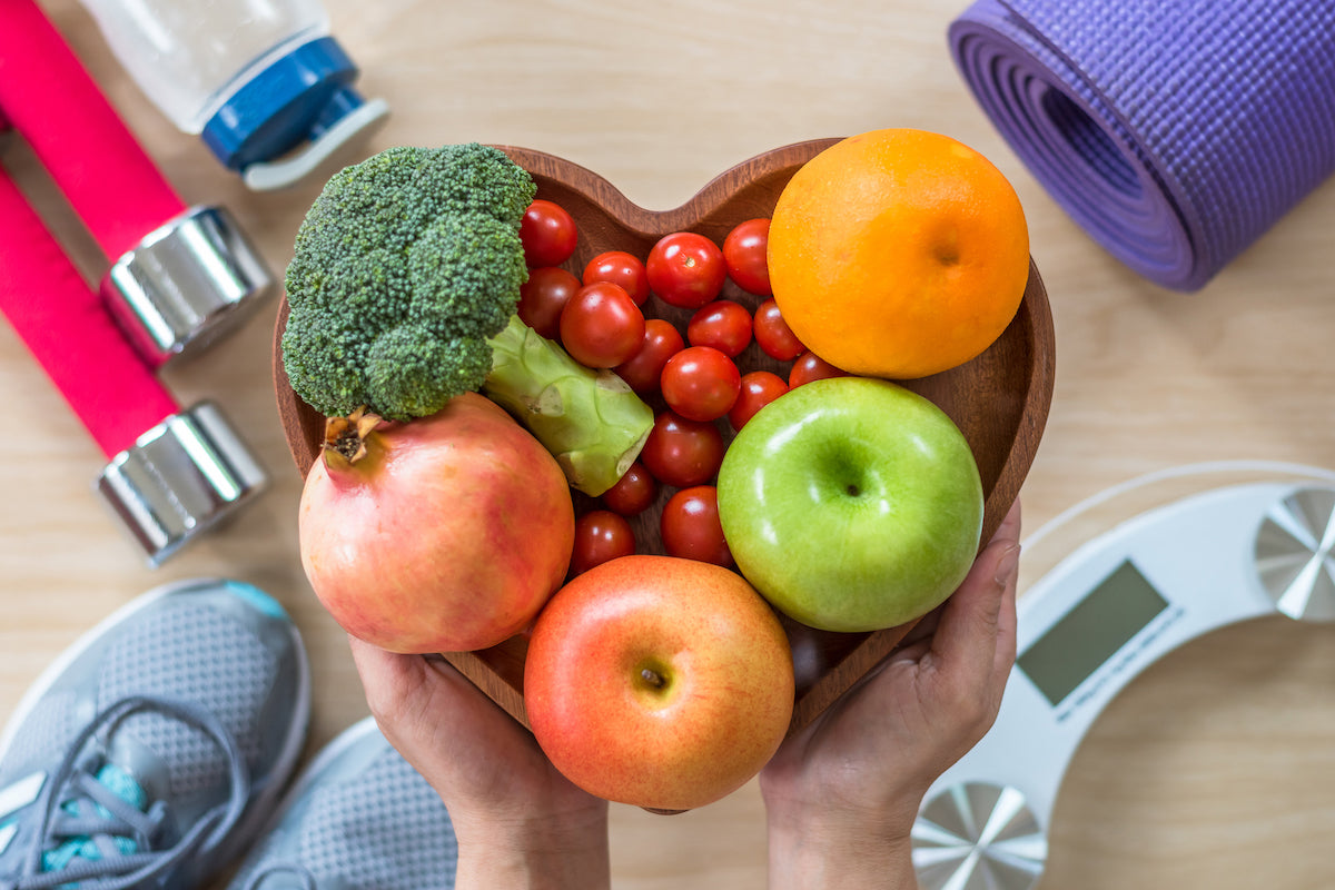 Obst und Gemüse, Hanteln, eine Waage und eine Sportmatte