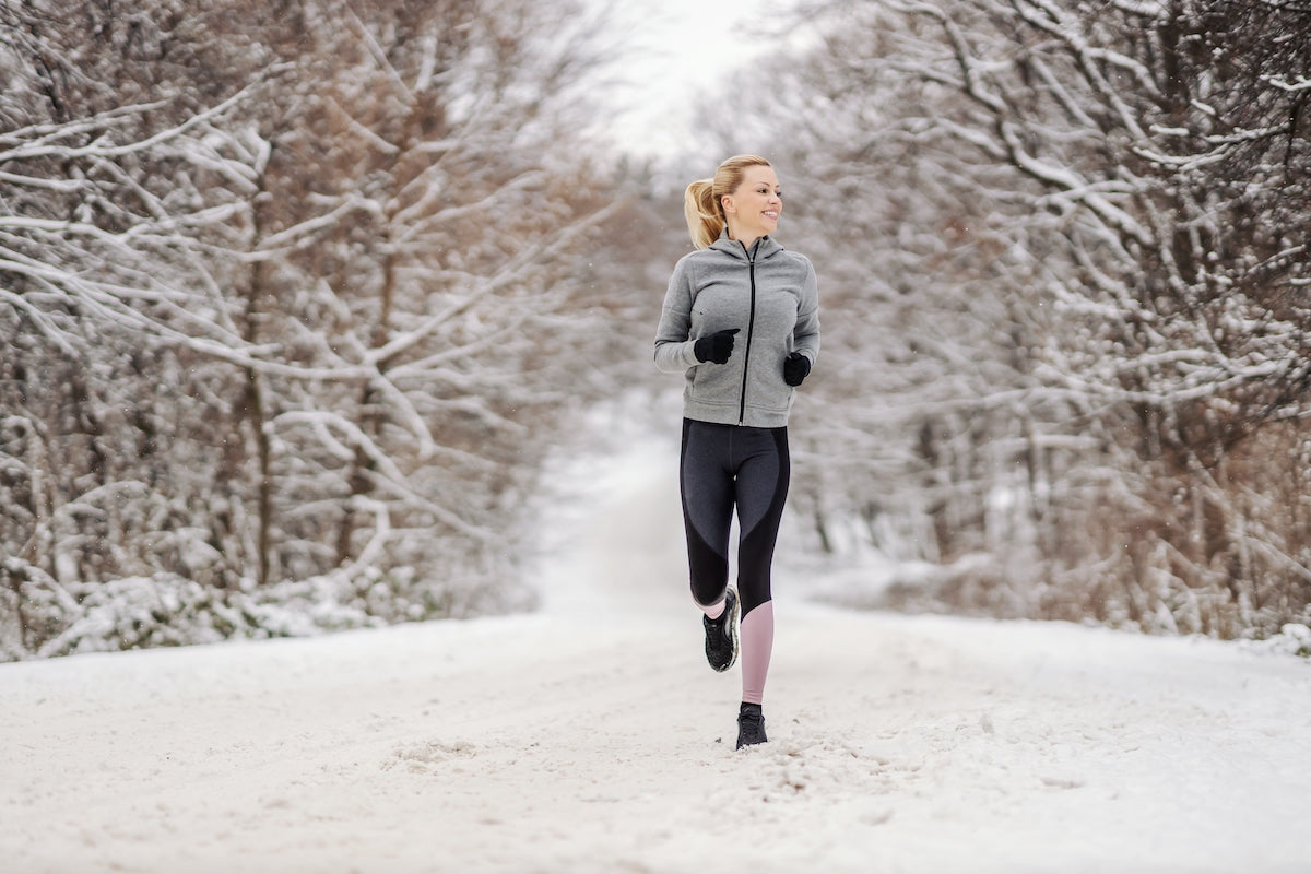 Eine junge Frau geht im Winter im Schnee joggen