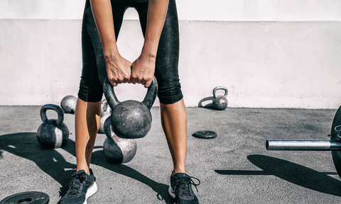 Frau hält Kettlebell in den Händen
