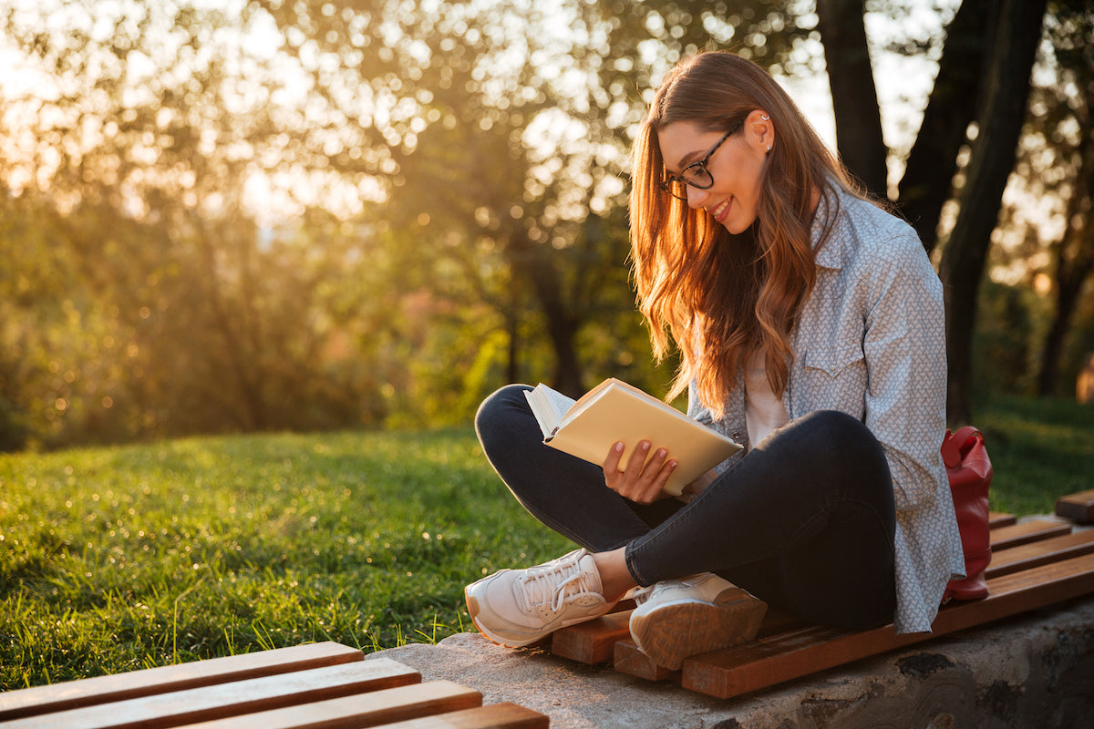 Frau liest draußen ein Buch
