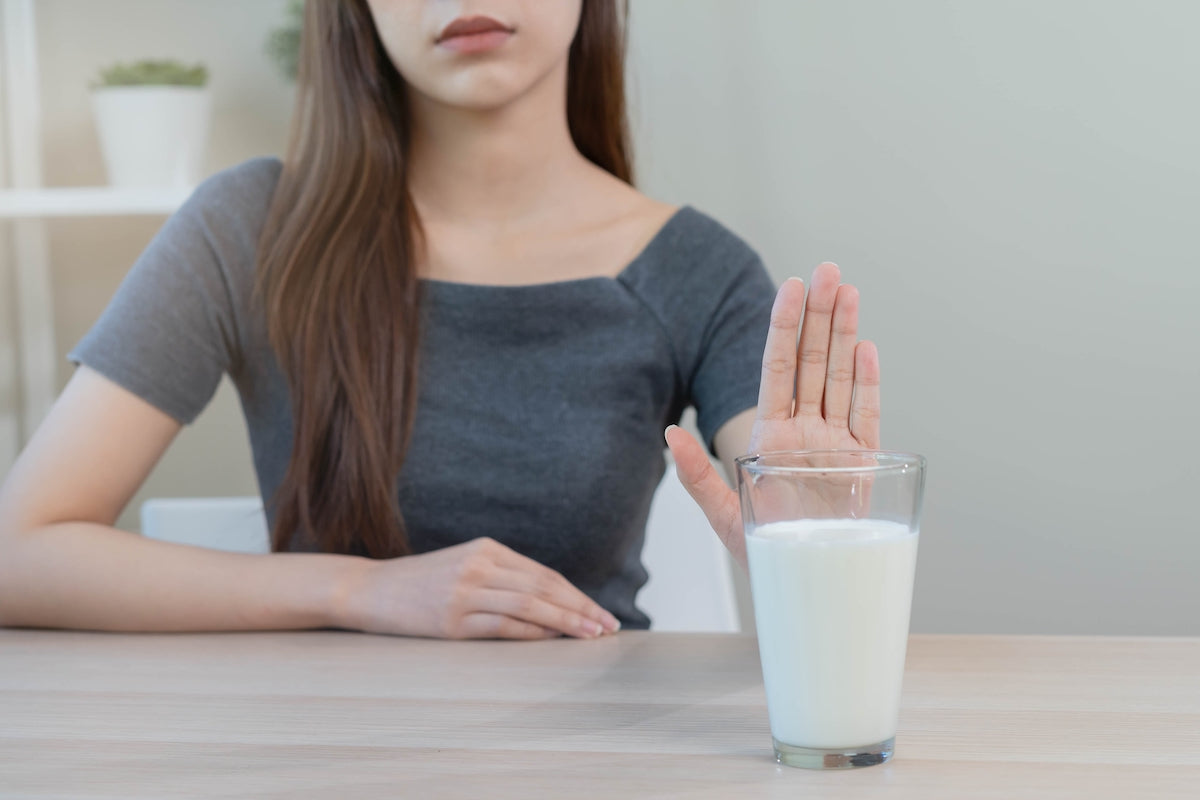 Frau lehnt Glas mit Milch ab