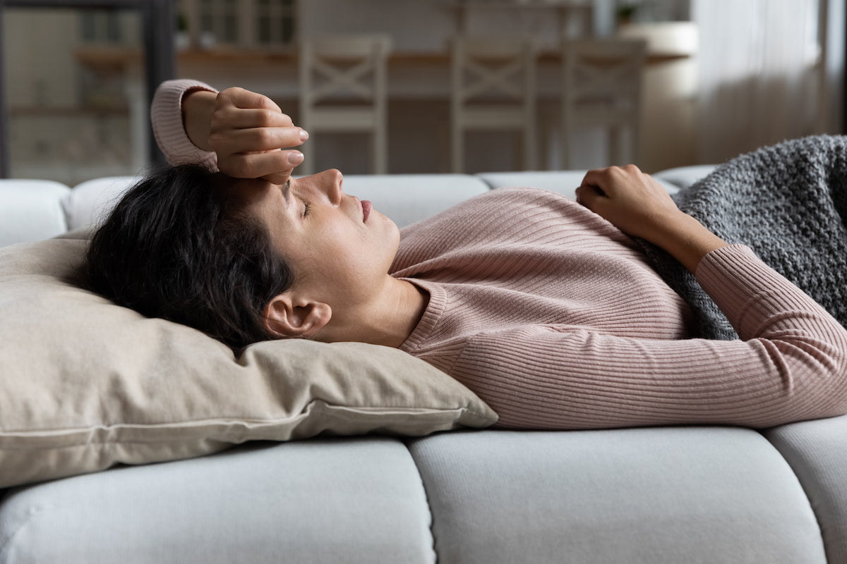 Frau liegt auf dem Sofa und ruht sich aus
