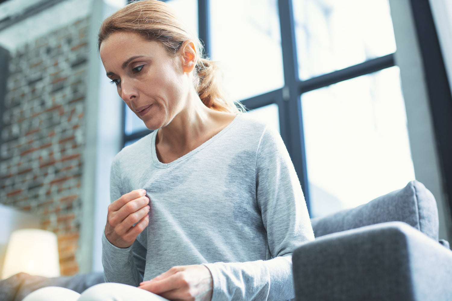 Eine Frau wirkt gestresst und hat Schweißausbrüche