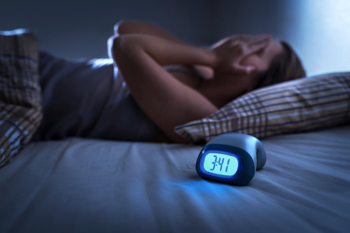 Frau liegt nachts im Bett wach