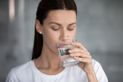 Eine Frau trinkt ein Glas Wasser