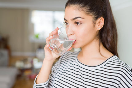 Ernährung in den Wechseljahren: Frau trinkt ein Glas Wasser