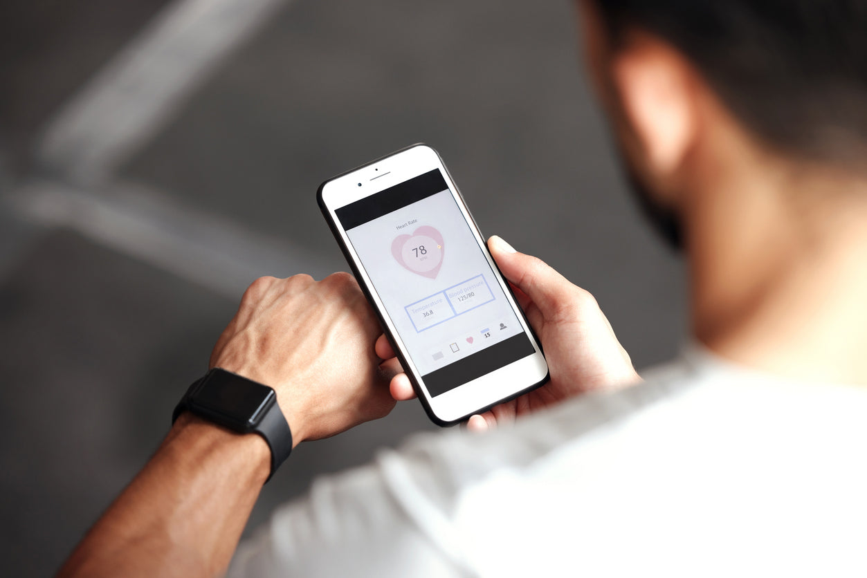 Fitness-Tracker Gesundheit: Mann verbindet seine Fitnessuhr mit dem Handy